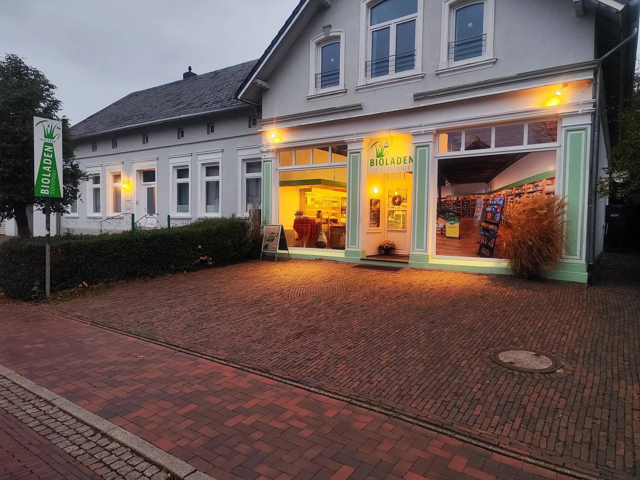 Der Bioladen Seidenspinner in der Bahnhofstraße 8 in Rastede — heller Altbau mit warm beleuchteten Schaufenstern